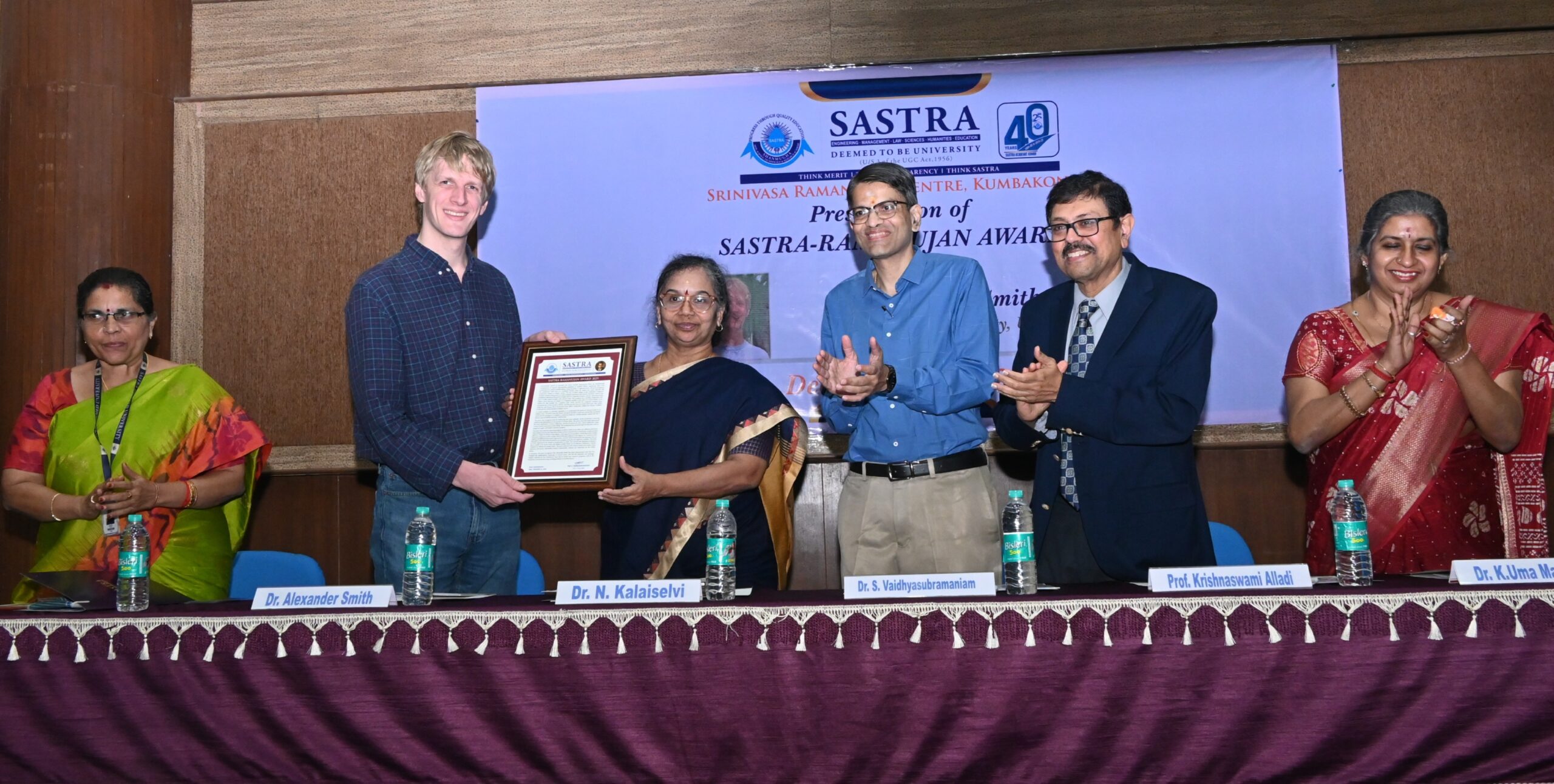 Alexander Smith receives the 2025 SASTRA Ramanujan Prize at SASTRA University, with Ms. Selvi, S. Vaidhyasubramaniam, and Krishnaswami Alladi standing nearby.